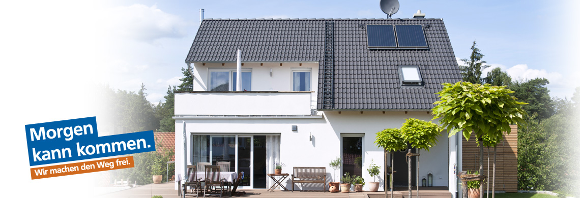 Modernes zweistöckiges Haus mit grauem Ziegeldach, weißen Außenwänden, großen Fenstern, Solarpanels und Satellitenschüssel; im Vorgarten stehen Pflanzen, Gartenmöbel und kleine Bäume. Text: ‚Morgen kann kommen. Wir machen den Weg frei.‘